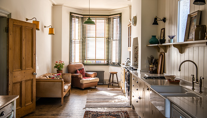 Here, cupboards from British Standard by Plain English are shown in a kitchen relocated to the front of a terraced property