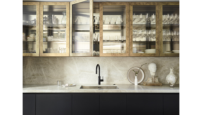 Also fitting the trend for fluted finishes is this stunning Roundhouse Urbo and Metro matt lacquer kitchen in Farrow & Ball’s 'Railings', teamed with upper cabinetry in an antique brass finish with fluted glass doors, and the Taj Mahal worktop and splashback