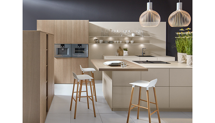 Pictured here in this contemporary kitchen design from Pronorm are two organic door finishes of Oak Trend, a premium real wood veneered door featuring a narrow-fluted design, and Angora Grey ultra-matt with its velvet soft texture and anti-fingerprint technology. The two finishes work harmoniously together to provide a modern yet homely aesthetic, while offering visual and textural contrast