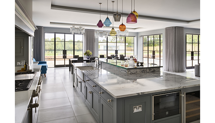 Injecting colour into this kitchen from Martin Moore, the cluster of Classic Glass Pendant lights from Curiousa and Curiousa have been strategically positioned above the island. Further statement lighting above the dining table is provided by three glass chandeliers
