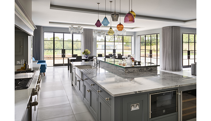 Injecting colour into this kitchen from Martin Moore, the cluster of Classic Glass Pendant lights from Curiousa and Curiousa have been strategically positioned above the island. Further statement lighting above the dining table is provided by three glass chandeliers
