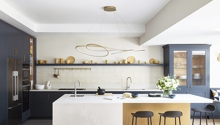 The L-shaped island in this contemporary Clarke kitchen by Roundhouse is accentuated by the Ribbon LED Ceiling Pendant XL from Heal’s, which is positioned above to create an eye-catching centrepiece