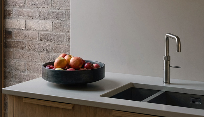 This project from Mowlem & Co focuses on an earthy colour palette to shows how a neutrally-toned worktop and splashback can be paired with exposed brickwork and wooden cabinetry