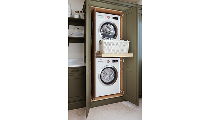 This tall-cabinet double-door washer/dryer stack by LochAnna is from their Newbridge range in the Brigade Shaker-style kitchen. Ideal for a client looking for a more traditional look in their utility room with a hidden pull-out laundry shelf  and open shelving for storage
