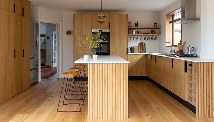 Oak overlay slab doors create a clean, modern look, while solid oak slatted end panels add texture